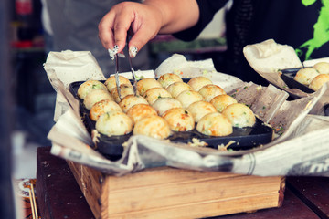 close up of cook hands with meatballs at street
