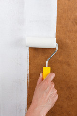 Paint roller isolated on wooden surface