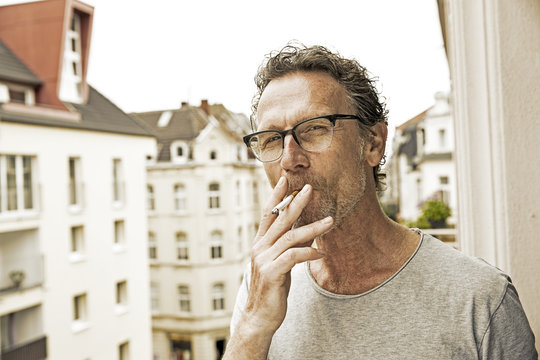 Portrait of man smoking on balcony
