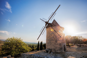 Naklejka premium Old stone windmill against sunset in Saint Saturnin les Apt, Provence, France