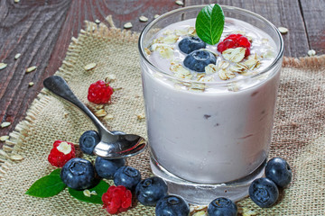 glass of fresh mixed berries, yogurt and granolas with farm fresh berries