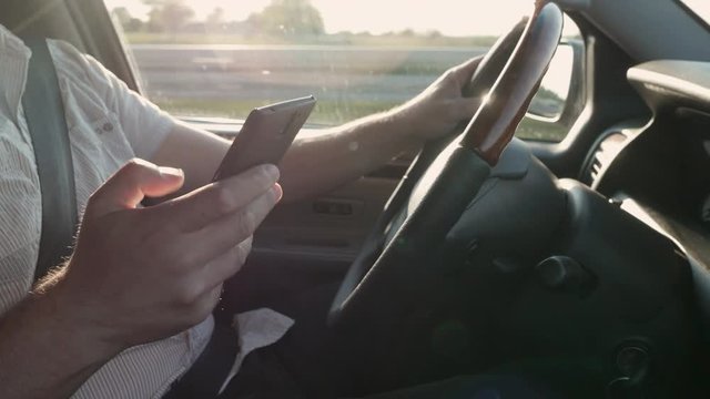 Man puts down his phone while driving.

