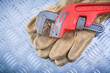 Leather protective gloves monkey wrench on corrugated metal back
