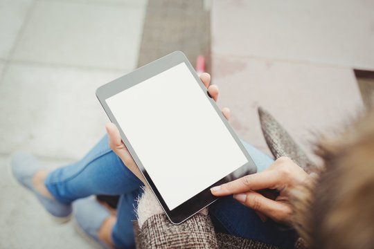 Low section of woman using tablet 