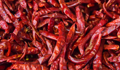 Dried chili peppers background. Many red hot pigments chile wallpaper, the combined or pile. Thai food seasoning. Close up and macro.