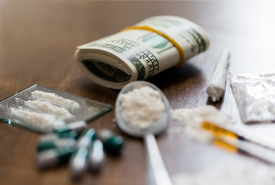 close up of drugs, money, spoon and syringe