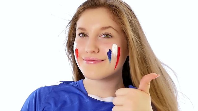 Girl with French flag on her face smiling with thumb up, slow motion