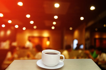 Blurred background : white cup of coffee and customer at restaur