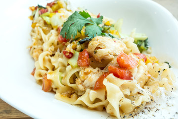close-up of plate of pasta and chicken with lettuce