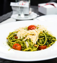 Pasta with pesto sauce and nuts on a the table