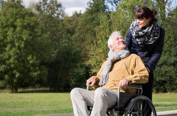Woman supporting man on wheelchair