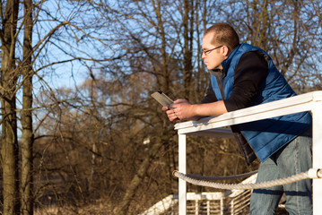 man with tablet computer in autumn forest