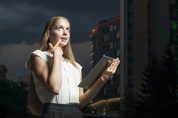 The woman with the tablet computer against office building