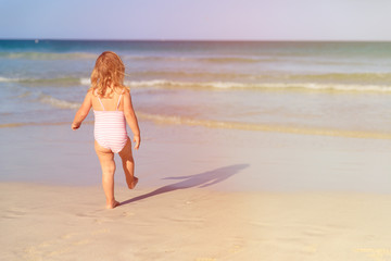 Fototapeta premium little girl going to swim at beach