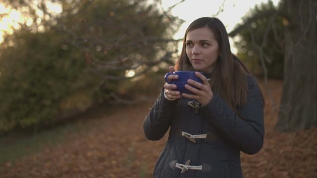 Woman drinking a hot beverage from a large mug.
