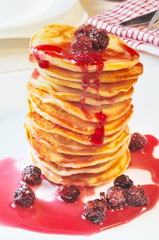 Pile of Pancakes with cherry jam in white  plate on the  table
