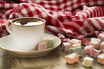 Turkish coffee, red plaid cloth and colored sweets on the wooden table 
