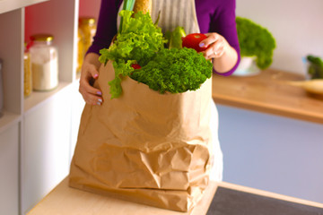 Healthy positive happy woman holding a paper shopping bag full of fruit and vegetables