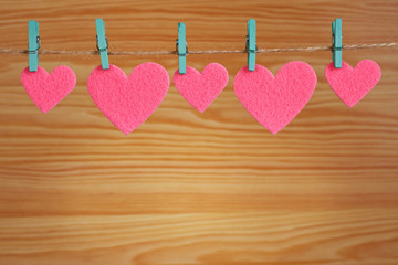 Fototapeta premium five pink hearts hanging on a cord 