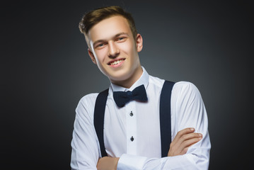 Happy boy. Closeup Portrait of handsome teenager smiling isolated on grey background