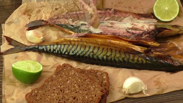 Whole smoked fish (mackerel) on a dark wooden table
