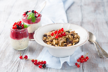 Healthy breakfast with yogurt, homemade granola and fresh berries, selective focus. White wooden background