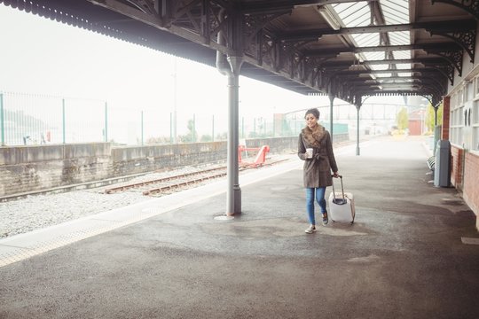 Full length of woman carrying baggage at station