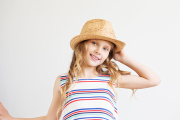 Lovely little girl with straw hat against a white background. Ha