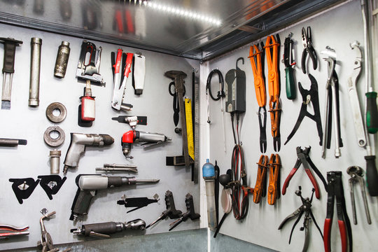 Assorted instruments for car maintenance on wall at service. Special tools for professional vehicle repairing