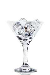 Ice cubes and martini glass on white background. Toned