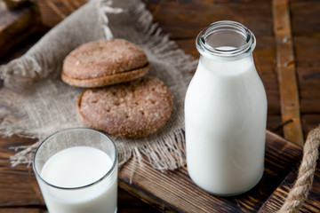 Natural whole milk in bottle and on old wooden background