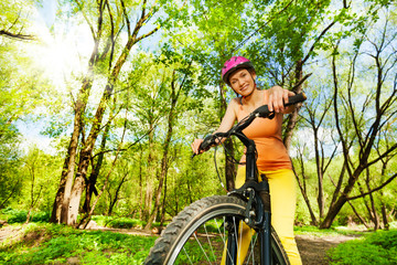 Active woman during the bike ride in sunny forest