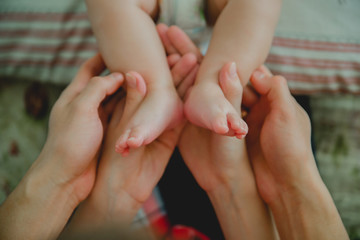 Fototapeta na wymiar Baby feet in mommy's hands