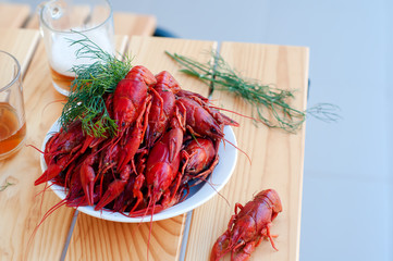 Tasty boiled crayfishes and beer on old table