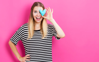 Happy young woman holding a heart cushion