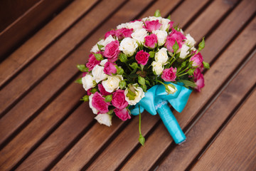 wedding bouquet of white and red roses on wooden background