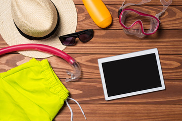 Summer accessories with white digital tablet on wooden table