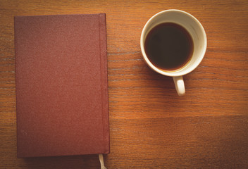 Obraz na płótnie Canvas closed notebook and cup of coffee-