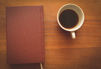 closed notebook and cup of coffee-