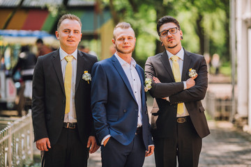 Three friends, groom with groomsman having fun