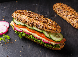 Whole wheat sandwich with cheese, tomato, lettuce and cucumber.