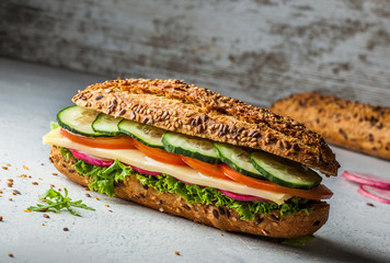 Whole wheat sandwich with cheese, tomato, lettuce and cucumber.