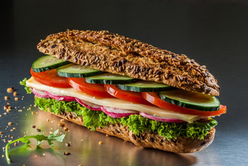 Whole wheat sandwich with cheese, tomato, lettuce and cucumber.
