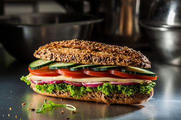 Whole wheat sandwich with cheese, tomato, lettuce and cucumber.