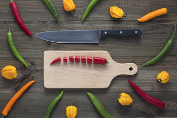 chopped cayenne chilli pepper on cutting board on blue wooden table. Image with copy space.