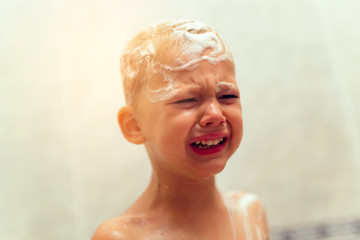 Boy taking a bath and crying. Little boy upset in a bathtub, mot