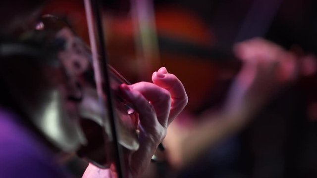 Hands of Musician Playing Violin in Dark Hall