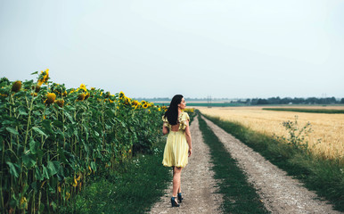 brunette girl relaxing outdoor near sunflower field