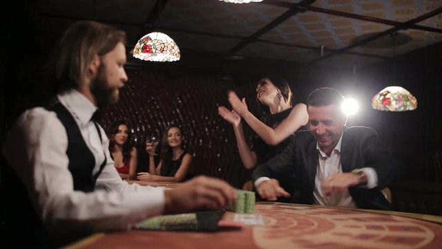Businessman with a young prostitute happy winnings at the casino .