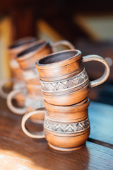 cups of red clay with a national ornament on the wooden table closeup